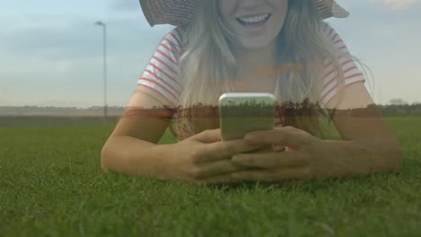 Mujer-Tumbada-En-El-Césped-Enviando-Mensajes-De-Texto-A-Su-Teléfono