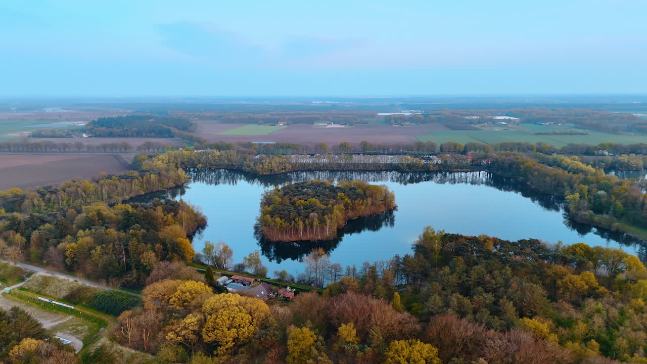 Serene Dutch landscape aerial. Lush greenery surrounds a tranquil lake in the Netherlands, showcasing the stunning beauty of European nature at dusk