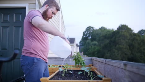 joven regando la cama del jardín
