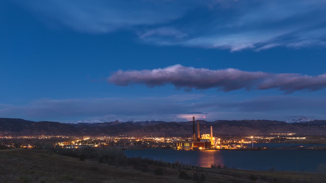 la puesta de la luna sobre las montañas de boulder colorado con una fábrica industrial