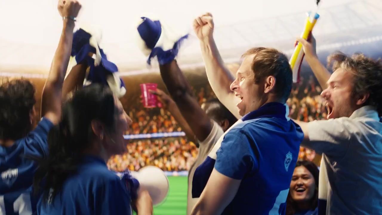 Vista trasera de aficionados de fútbol felices con camisetas azules levantando los puños para celebrar