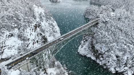 Luftaufnahme-Von-Autos,-Die-über-Den-Täuschungspass-Fahren,-Während-Schnee-Aktiv-Fällt