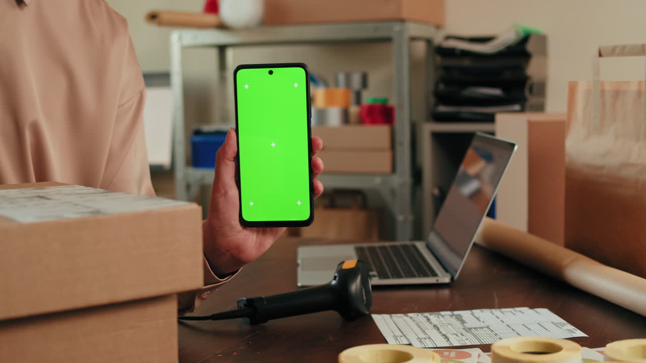Business Person Using Smartphone with Green Screen in a Shipping Office