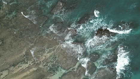 flying above the beach, with interesting pattern of waves and coral merging into a unique visual taken at pelabuhan ratu area, in indonesia