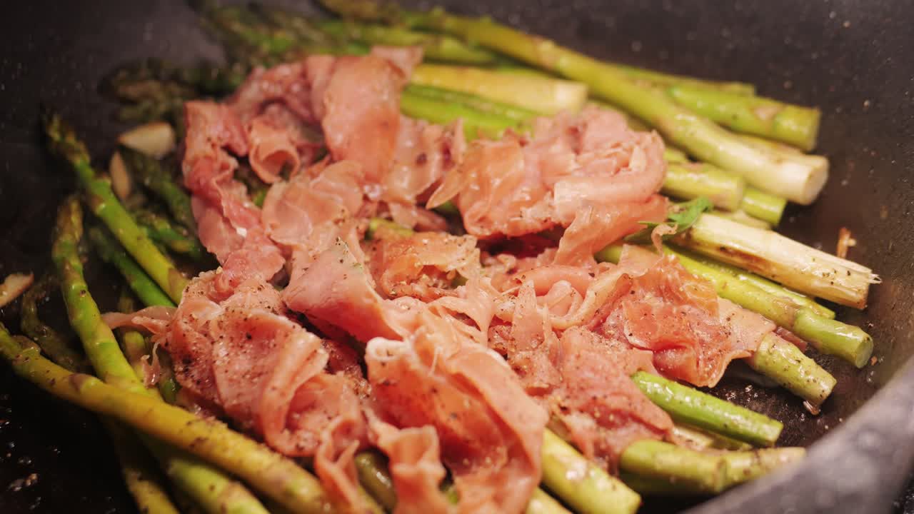 Grilled green asparagus with Jamon pork, bacon beef cast iron plate, chef cooking Spanish traditional food, green vegetables in cafe kitchen, top view