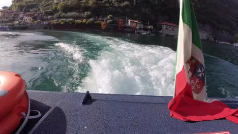 vista de la parte trasera de un barco que sale de monte isola durante una tarde de sol de otoño
