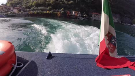 view of rear of a boat leaving monte isola during a afternoon autumn sun