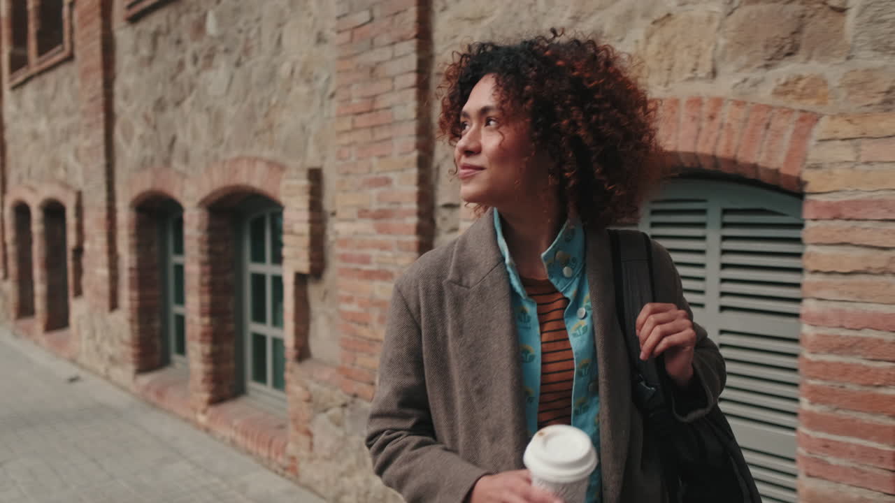 Young Woman Walking with Coffee and Backpack
