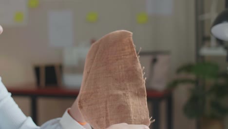 close up of asian woman designer looking at the fabric in hands