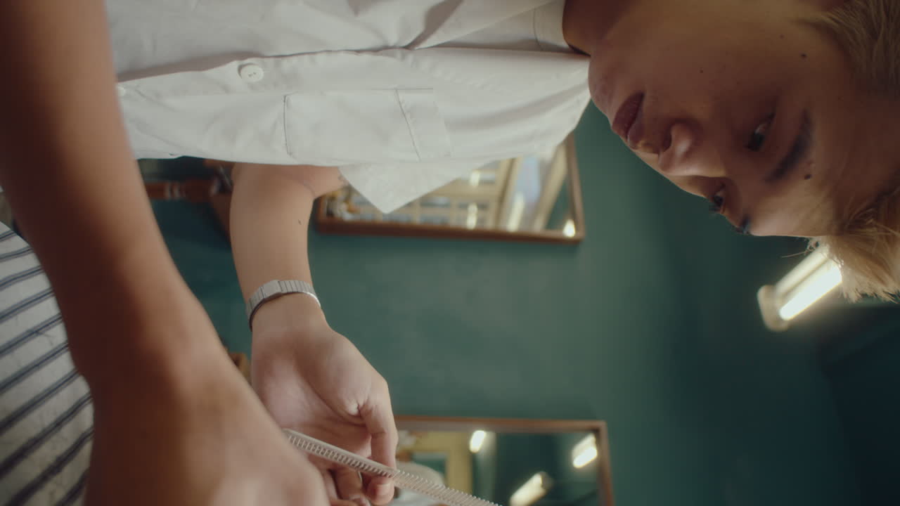 Asian Barber Using Hair Clippers and Comb at Work
