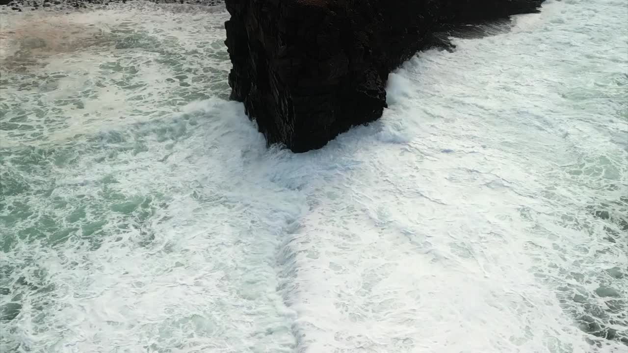 폭력적인 파도가 반도의 날카로운 셰일 가장자리를 부수고 시 오두막과 안개가 가득한 해안가를 드러내는 드론