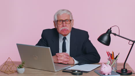 Senior-mature-older-office-businessman-working-on-laptop-computer,-making-funny-face,-fooling-around