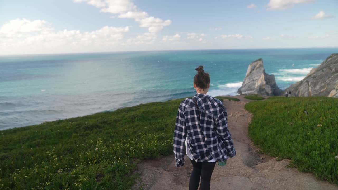 Woman Hiking Along a Coastal Path