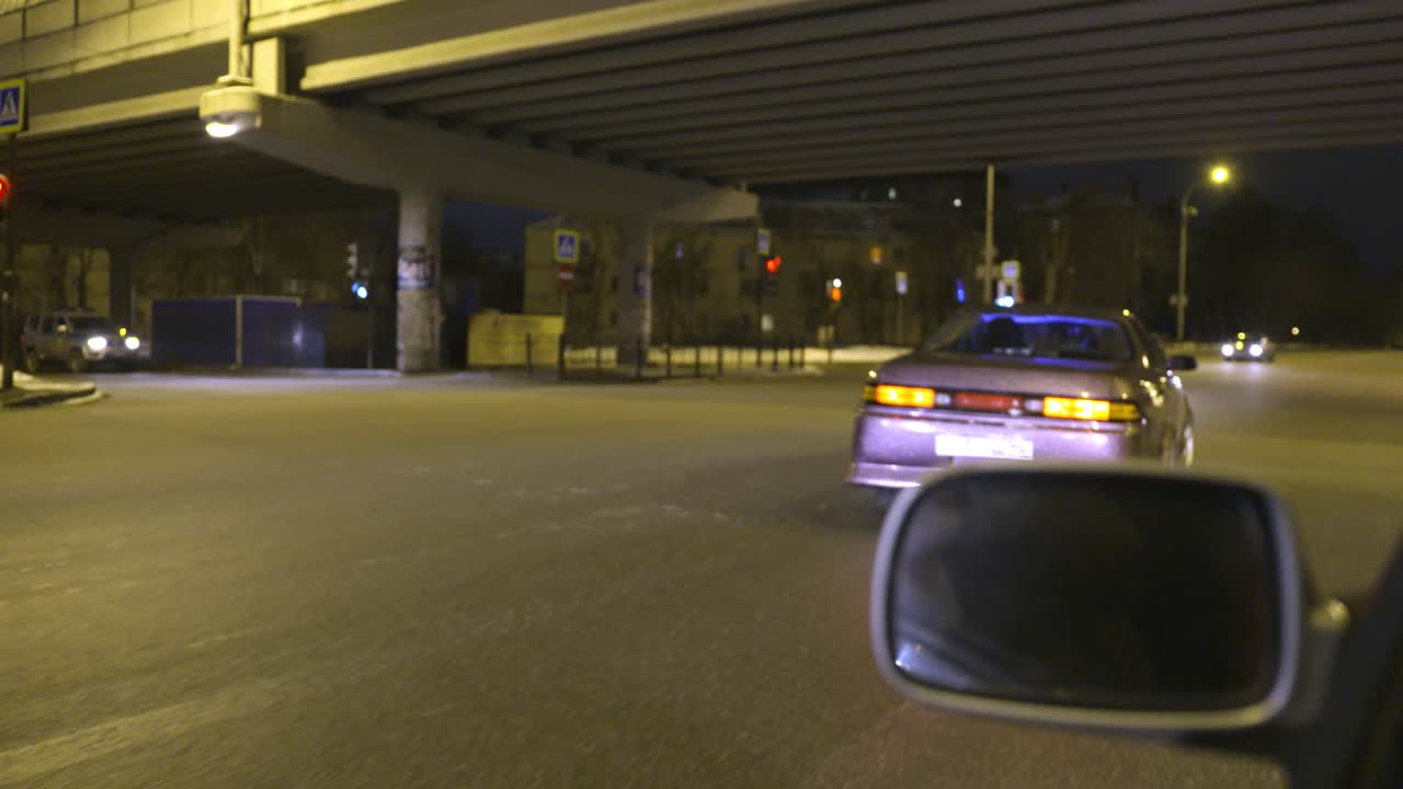 도시에서 밤에 운전하는 보라색 자동차