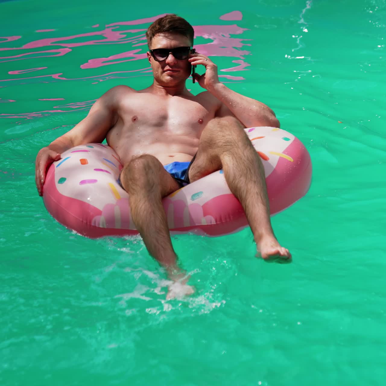 Attractive vacation lifestyle near pool. Man in pool swimming
