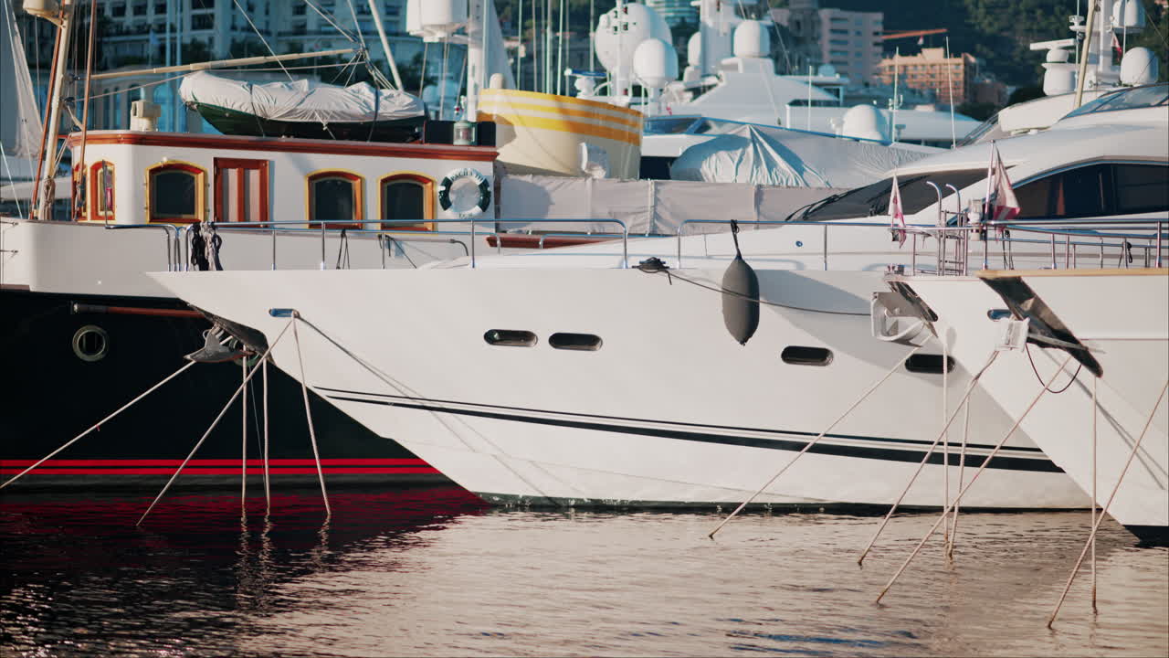 View of boats docked in the Monaco Marina with the skyline of the city on the background