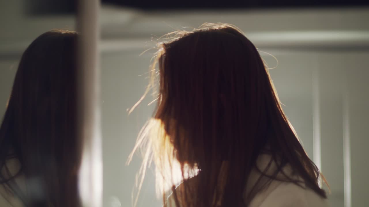 집 욕실에서 목욕 가운을 빗질 머리를 입고 갈색 머리 여자