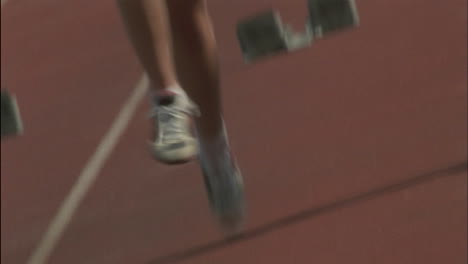 a young woman begins a race knocking the blocks flying