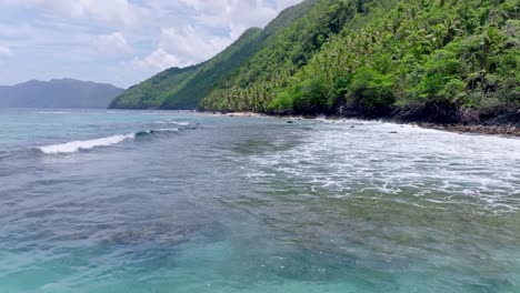 drone flight over waves crashing on playa ermitaño coastline in samana, dominican republic