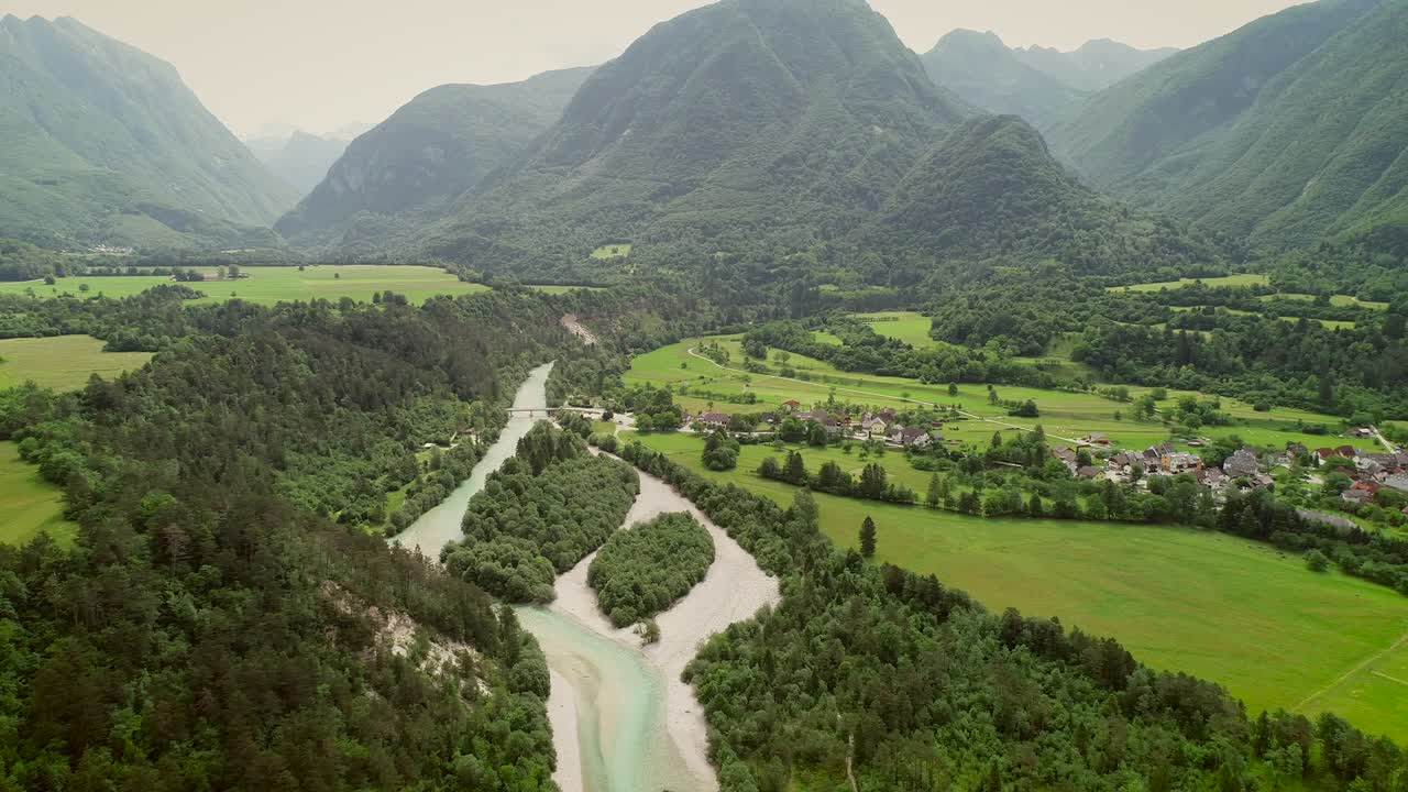 vista aérea de un pequeño pueblo con casas típicas junto al río soca, eslovenia.