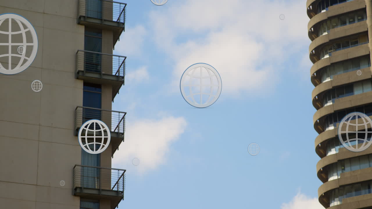 높은 건물과 파란 하늘을 배경으로 떠다니는 여러 웹 글로브 아이콘의 애니메이션