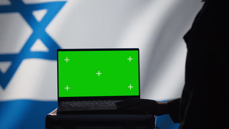 un agente de la policía secreta de israel utiliza herramientas de propaganda masiva en una computadora portátil de pantalla verde