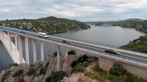 puente de hormigón blanco sobre un río con algo de tráfico