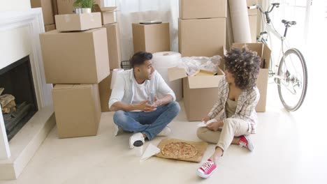 pareja joven tomando un descanso de la mudanza