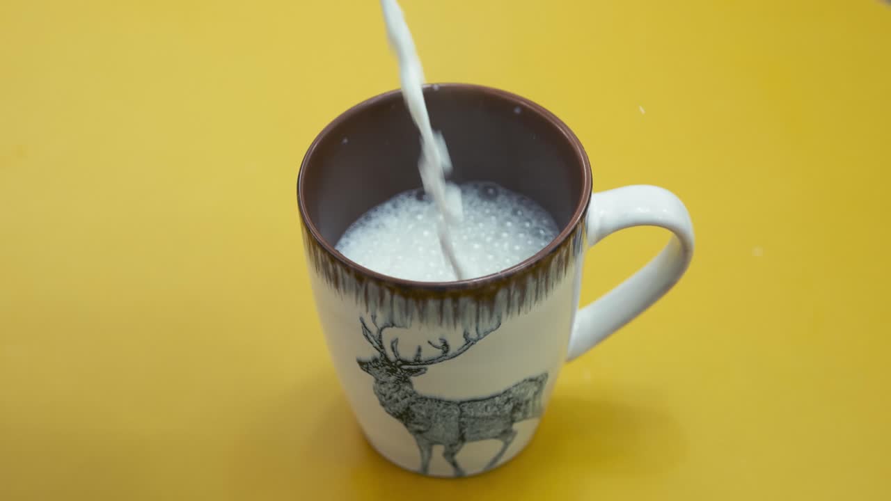 Hot Milk Pouring Into Mug On Yellow Surface