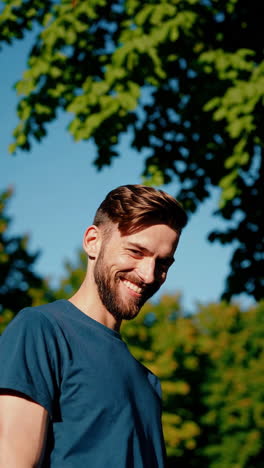 a man smiling outdoors on a sunny day