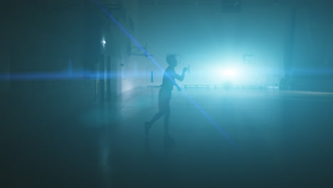 jugador de baloncesto en solitario recortado contra una fuerte luz de fondo