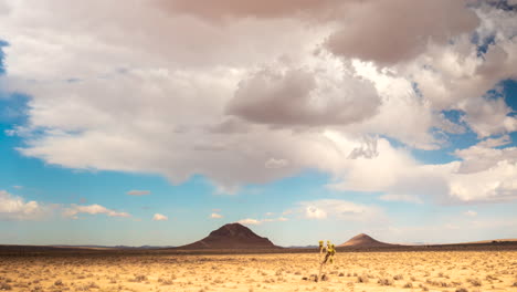 Sorprendente-Hiperlapso-Aéreo-De-Retroceso-De-Conos-Volcánicos-Inactivos-En-El-Desierto-De-Mojave-Con-Formaciones-De-Nubes-Dramáticas-Arriba