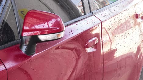 red car being washed at car wash