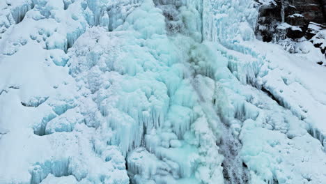 frozen waterfall in norway near rovijoen putous, icy cascades with flowing water