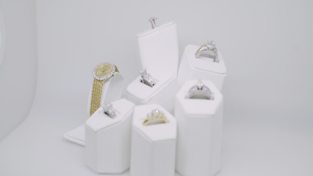 Beautiful Sparkling Gold Watch Beside Rings in Jewelry Display
