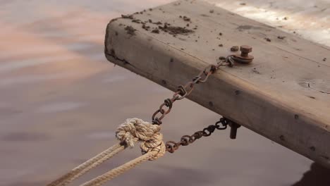 primer plano de una cuerda y cadena utilizadas para amarrar barcos en un muelle del puerto.