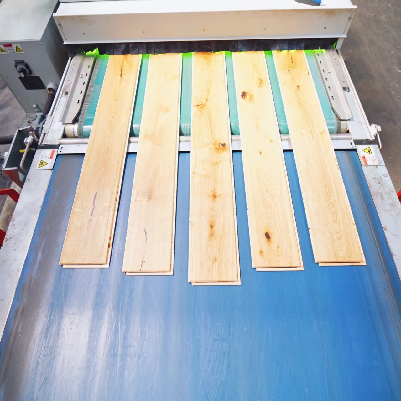 Interior of a laminate production. Top view of wooden boards moving on conveyor line inside the parquet factory.