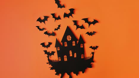 Spooky-Halloween-Haunted-House-With-Flying-Bats-on-Orange-Background