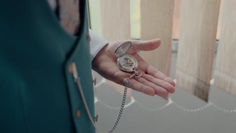 groom holding an open pocket watch, highlighting timeless elegance and attention to detail