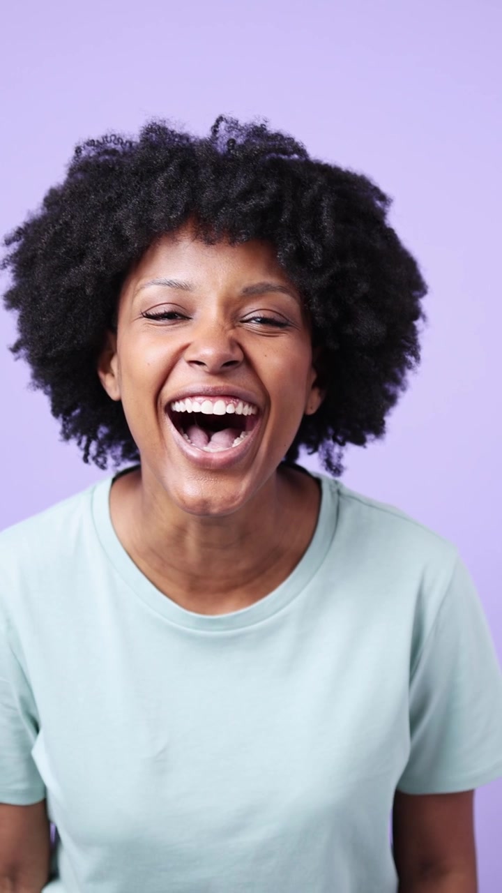 Cheerful Young African American Woman with Afro Laughing Heartily