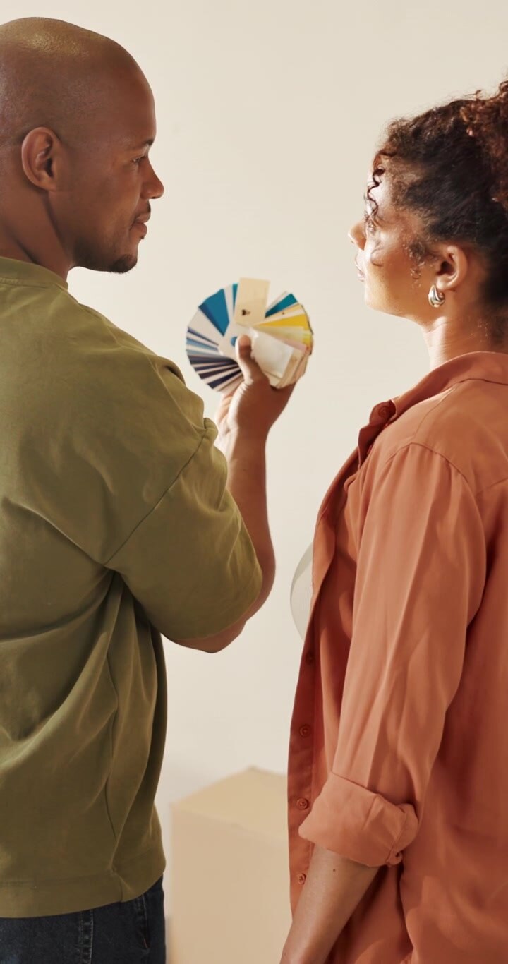 Couple Choosing Paint Colors from Swatch Fan in New Home