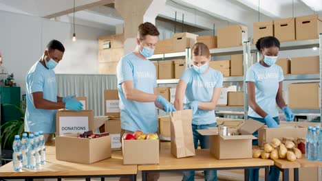 grupo multiétnico de voluntarios en máscaras faciales empacando cajas con comida y ropa y dándoselas a personas sin hogar en un almacén de caridad