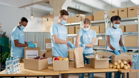 multiethnic group of volunteers in facial mask packing boxes with food and clothes and giving it to homeless people in charity warehouse