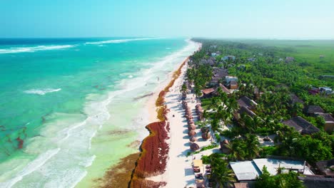 aerial drone footage of beautiful caribbean beach coastline with hotels and luxury resorts in tulum mexico