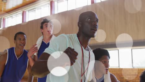 animation of light spots over diverse male basketball team screaming with joy