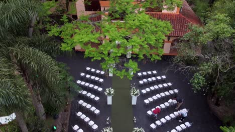 pan up from wedding ceremony set-up to stunning orange villa