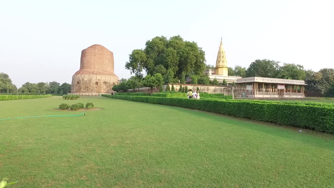 Un'ampia panoramica scorrevole che si affaccia sui prati verdi allo Stupa di Dhamek a Varanasi, India