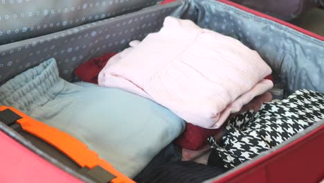 woman packing clothes in suitcase