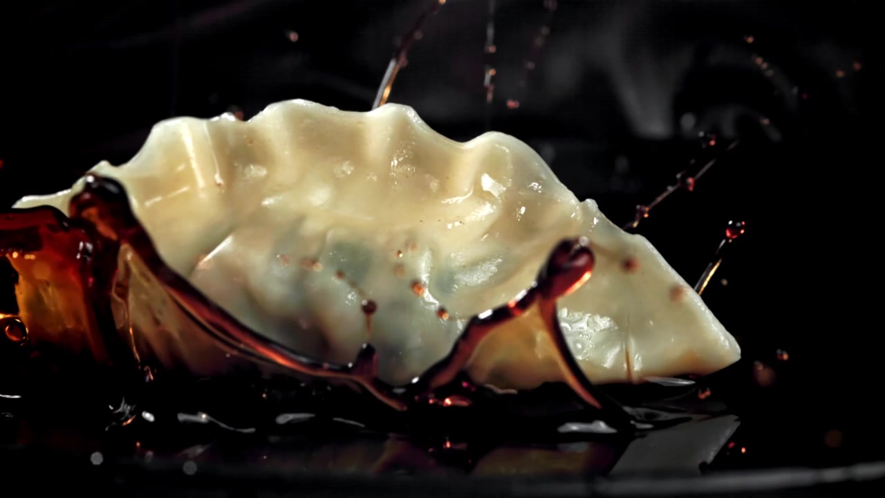 Delicious Gyoza Dropping into Soy Sauce in Slow Motion