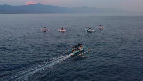 Antenne-Von-Indonesischen-Jukung-Booten,-Die-Bei-Sonnenaufgang-Auf-Dem-Ruhigen-Blauen-Ozean-In-Lovina-Bali,-Indonesien,-Auf-Der-Suche-Nach-Delfinen-Fahren